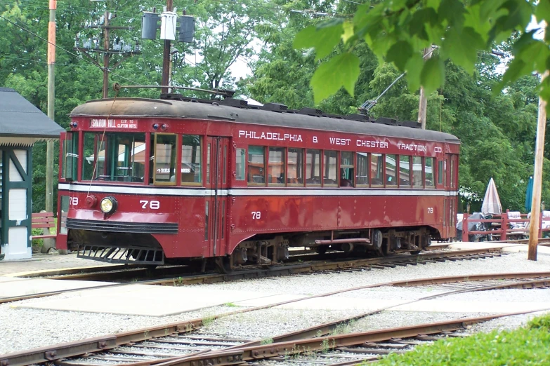 an old style trolley car is parked in a train yard