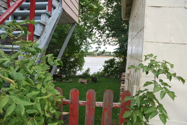 there is a bench near the house and water