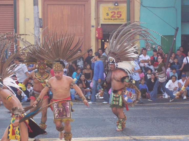 men in native american regalia dancing with a crowd