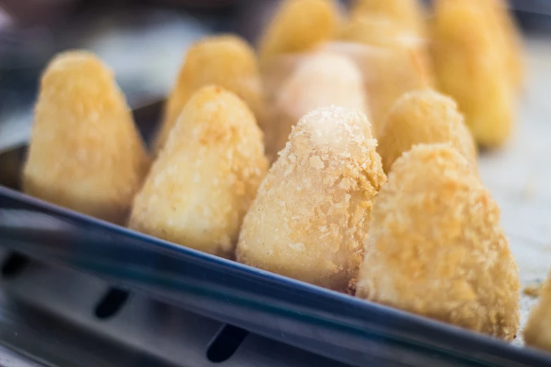 pastries placed in a metal container with a glass lid