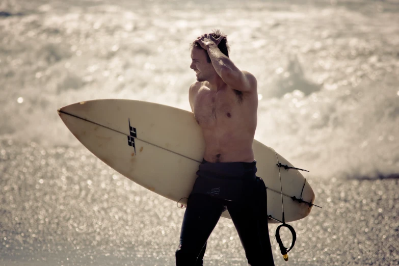 a man carrying a surf board on the beach