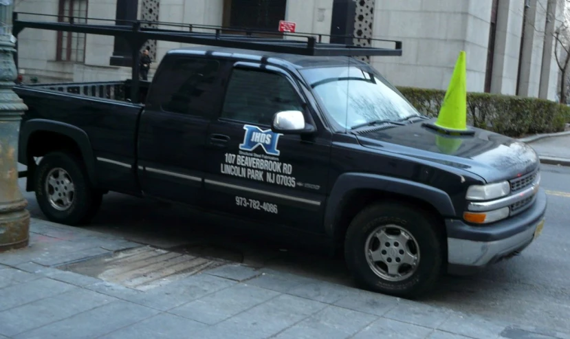 an extra long black truck with a sign on its hood