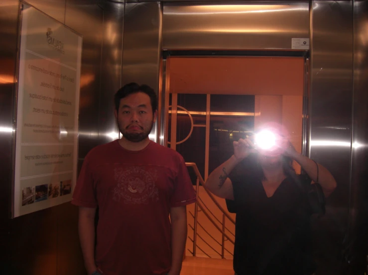 a man and woman in an elevator with their cameras