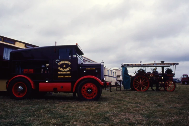 a large truck parked next to a tractor in a field