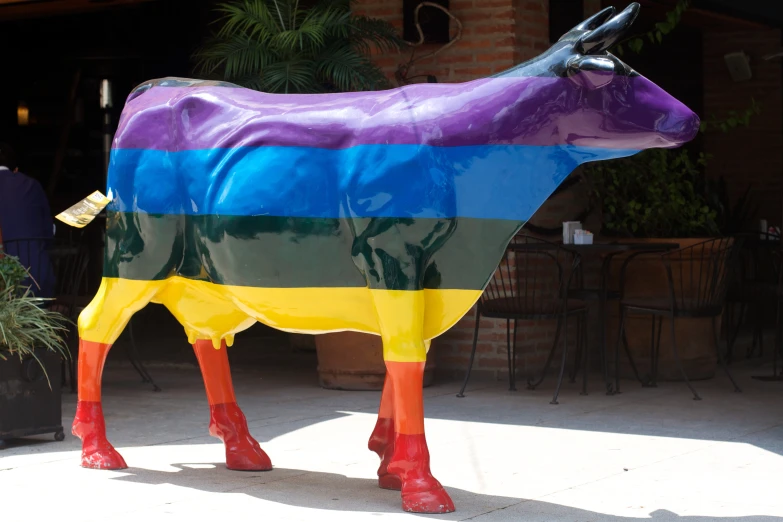 a statue of a cow is painted multicolored