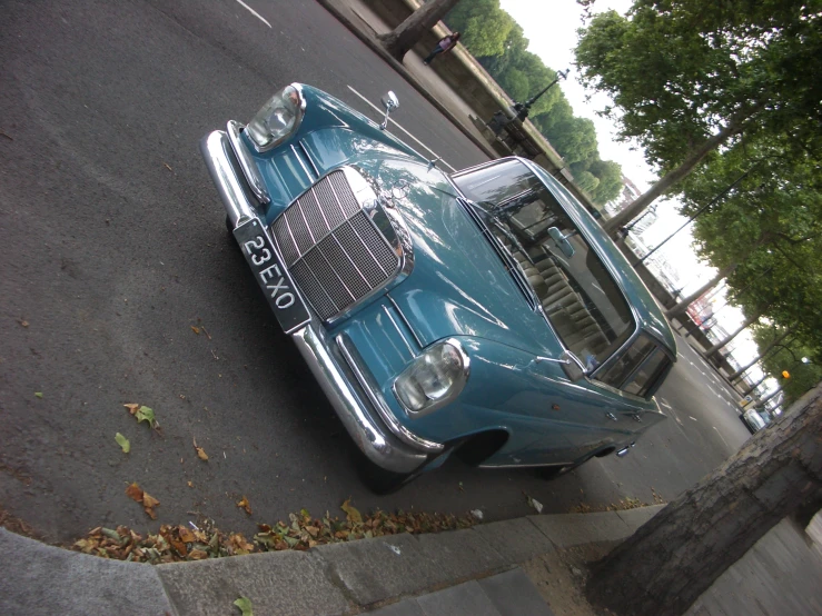 a blue classic car is parked on a street