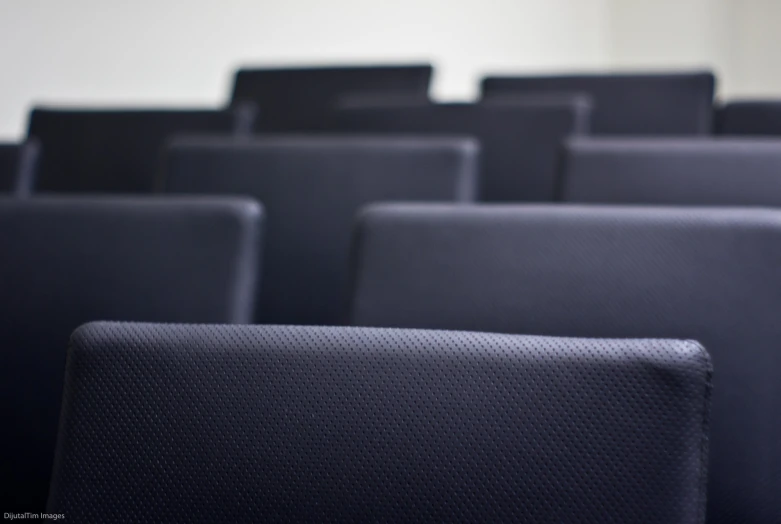 several seats with different styles and designs, all covered in black fabric