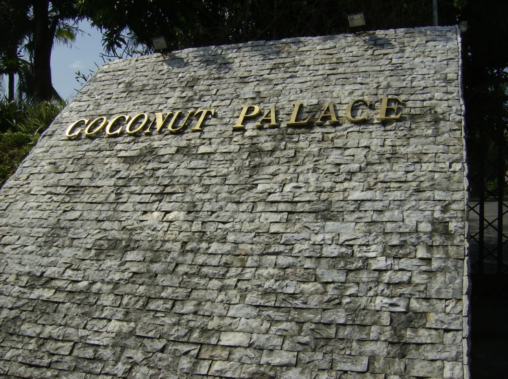 a brick wall with a plaque that says coconut palace