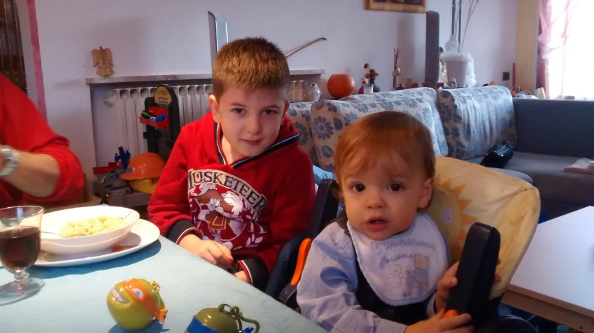 two little boys who are holding food and eating