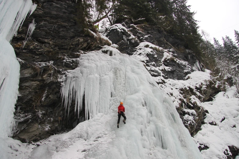 a man that is standing in the snow near some ice