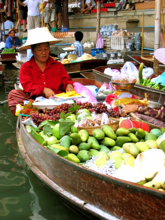 a woman selling fruits on a small boat