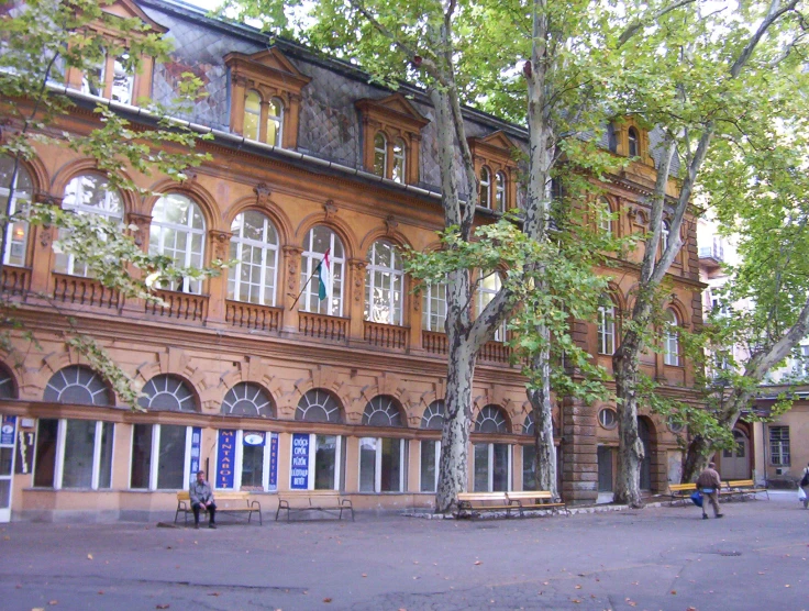 a man sitting on a bench in front of a building