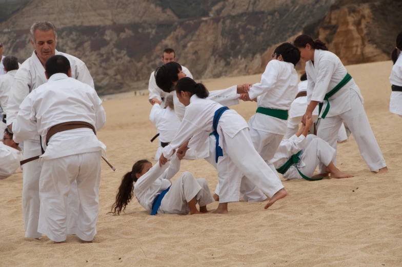 a group of karate players performing on the sand