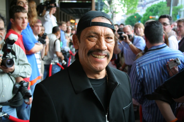 a man with a mustache and a head band in front of people