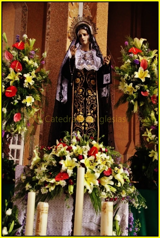 a shrine with candles in front of a statue of st benedict