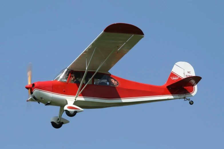a small airplane flying in a bright blue sky