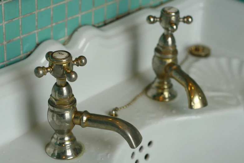 a couple of ss faucets sitting on a sink