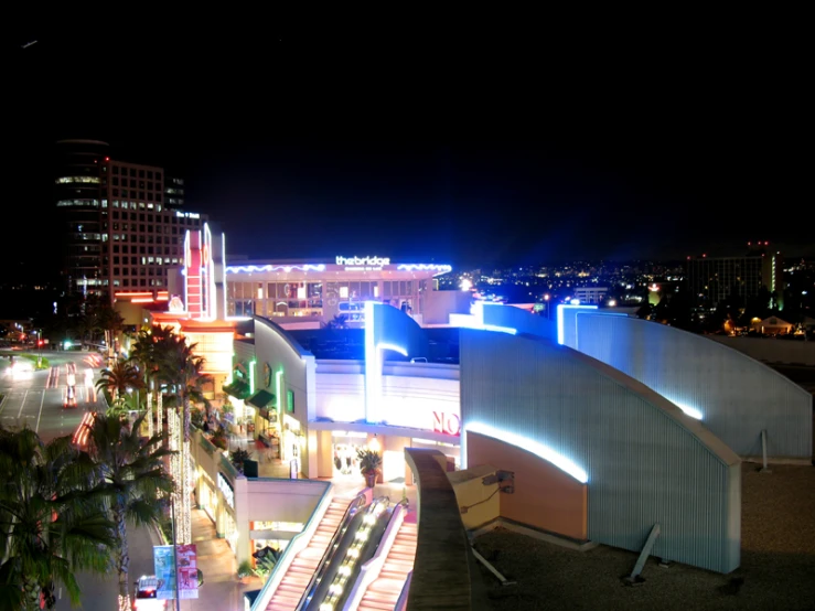 an illuminated building at night with the city lights lit up in the background