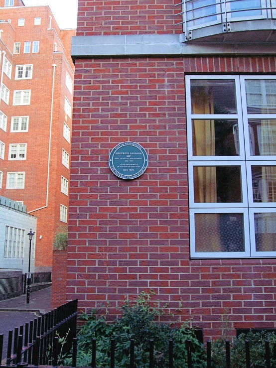 a brick building has a blue plaque on it