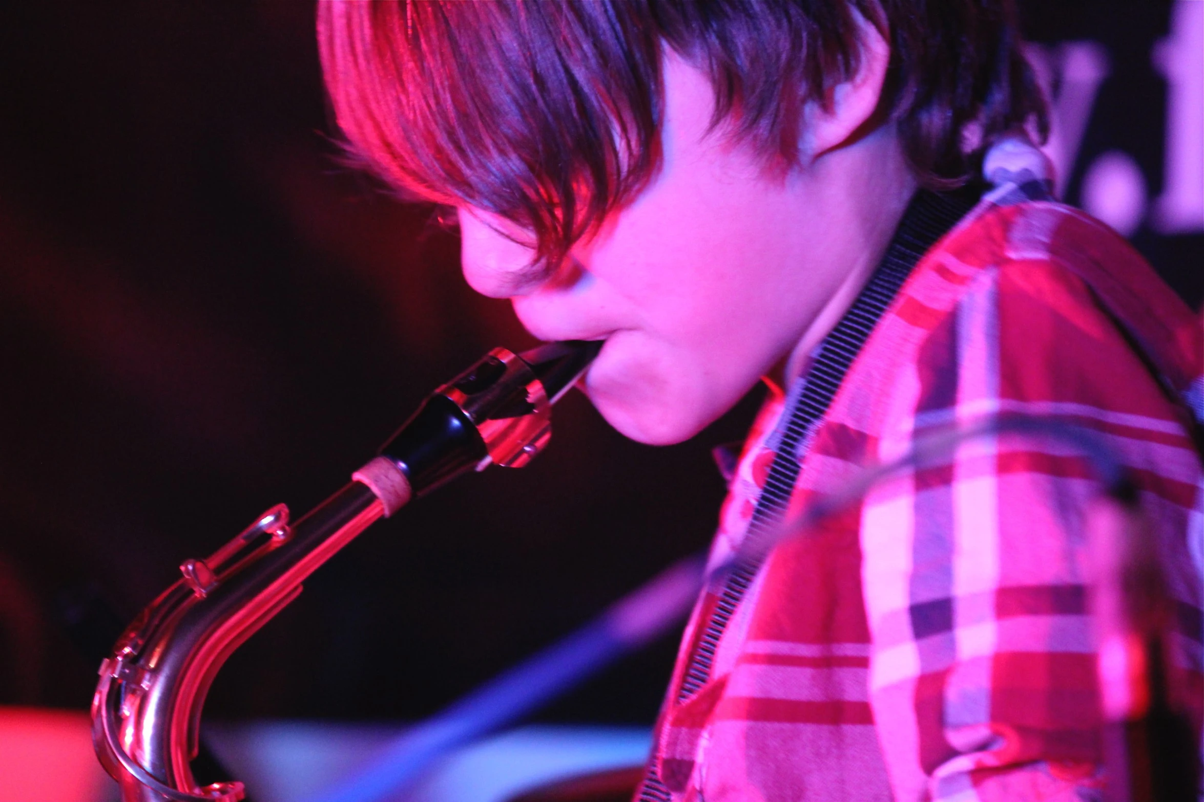 a  playing a saxophone in front of the camera