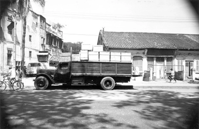 black and white pograph of an old truck parked in front of a house