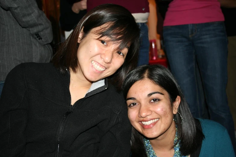 two women are smiling in a crowd