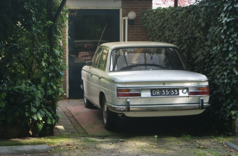 a vintage station wagon is parked in front of a house