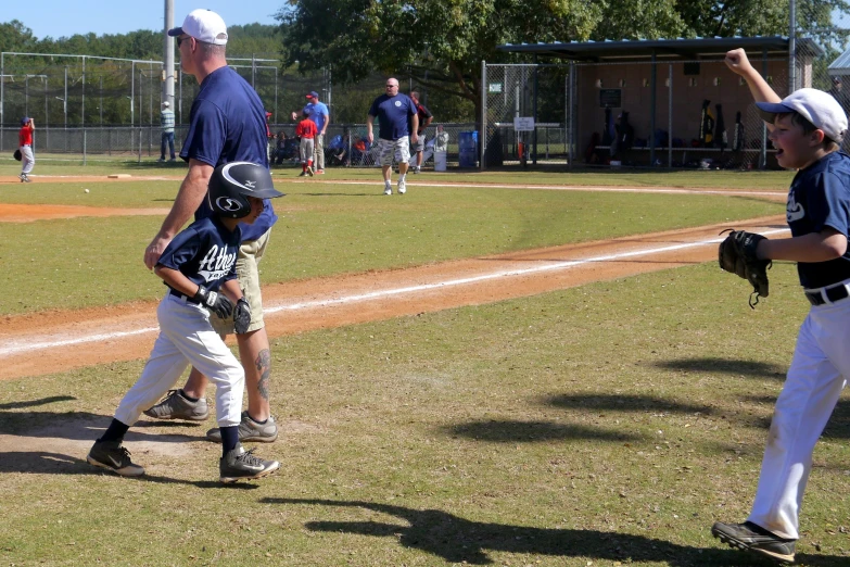 a young baseball player with a glove standing next to home plate