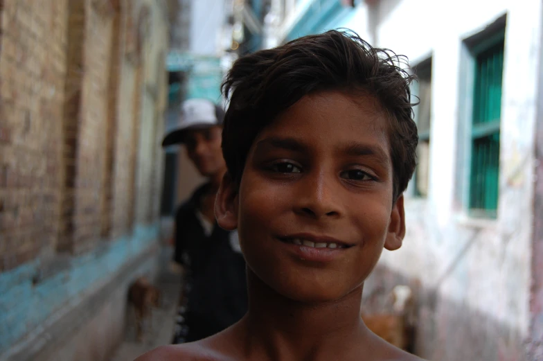 the boy is smiling by his face and one of his other men are in the background