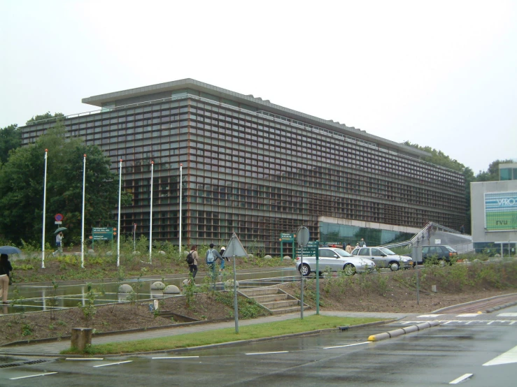 a large building is next to the highway with cars parked near it