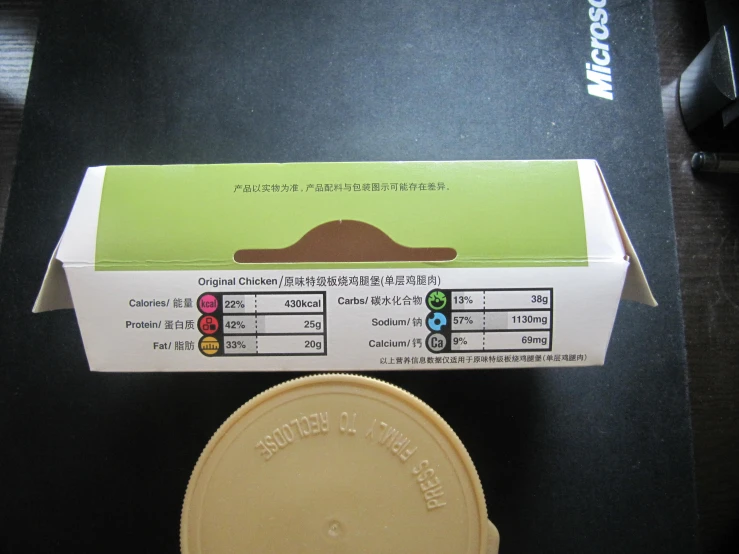 a green and white box next to a brown disc