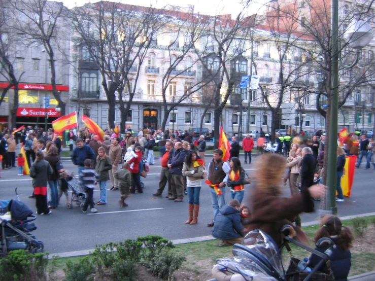a woman is holding onto a crowd with flags in the street