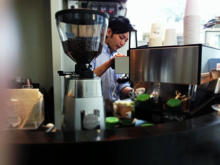 man in kitchen setting with espresso machine and food