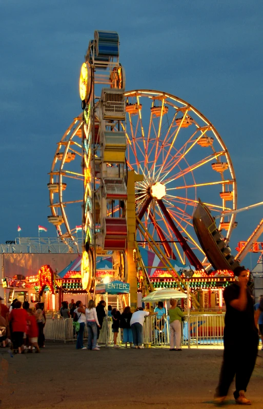 a ferris wheel next to a carnival at night