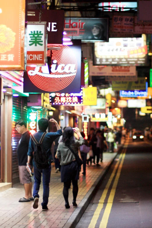 many people are walking down a crowded street at night