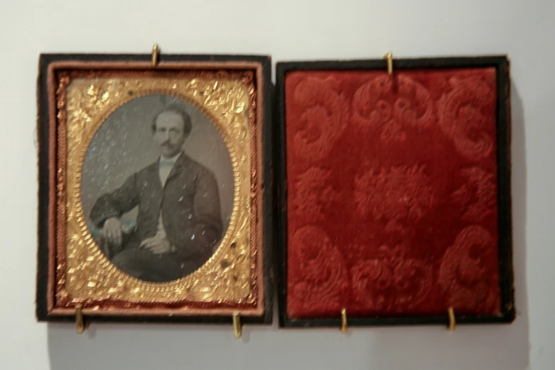 a brown and red painting next to a brown picture frame