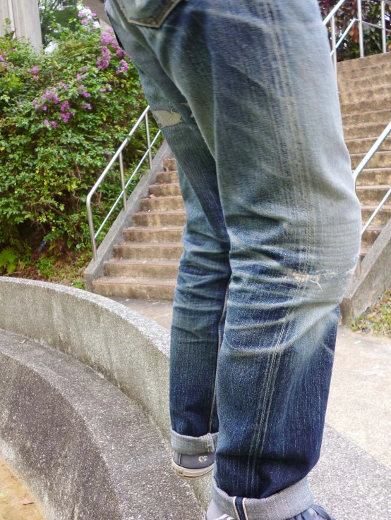 a person in a black shirt and jeans is standing near stairs