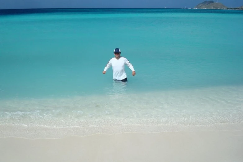 a man is standing in the water on a beach