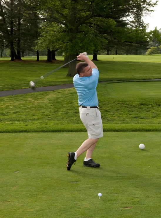 a man hitting a ball with a tee at the same time