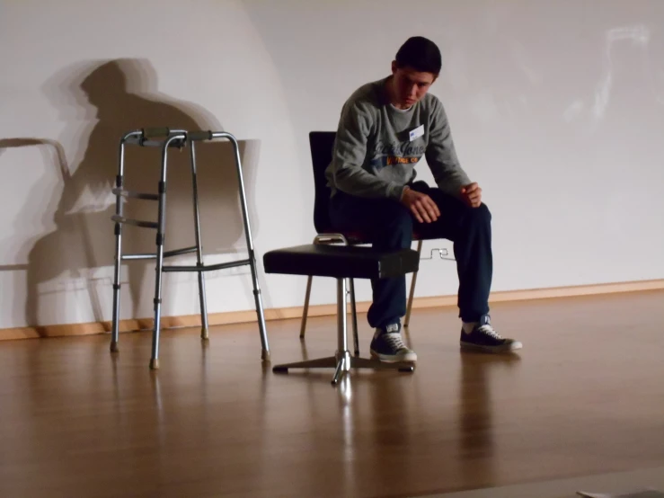 a man sitting on a chair near a tall bar stool