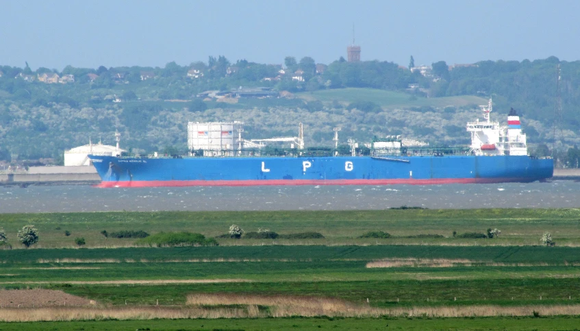 a large cargo ship sailing in front of a dock