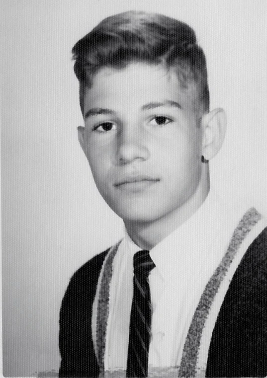 a boy poses for a pograph in a sweater and tie