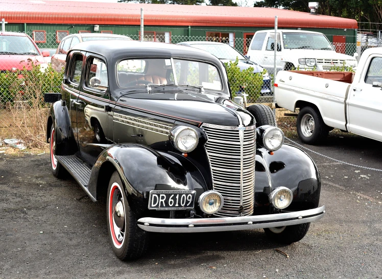 old style black car in parking lot near other vintage cars