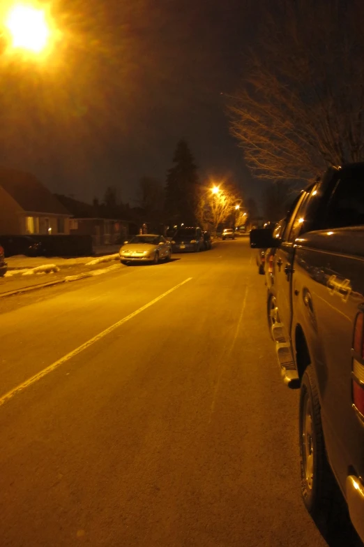 a night time street scene with two trucks parked in the middle