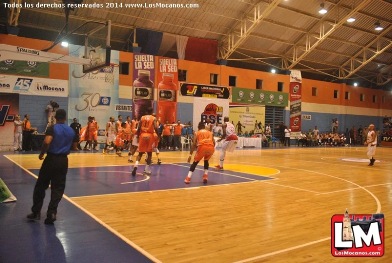 people are playing basketball at the indoor court