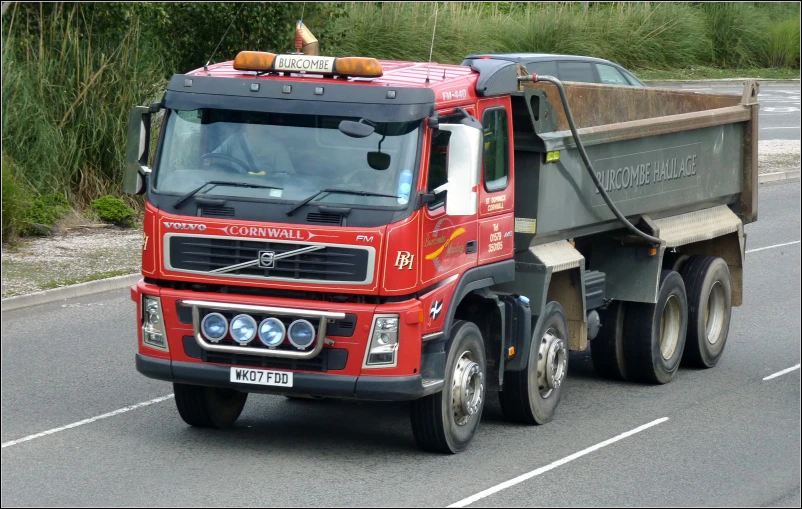 a dump truck traveling down the highway on a sunny day