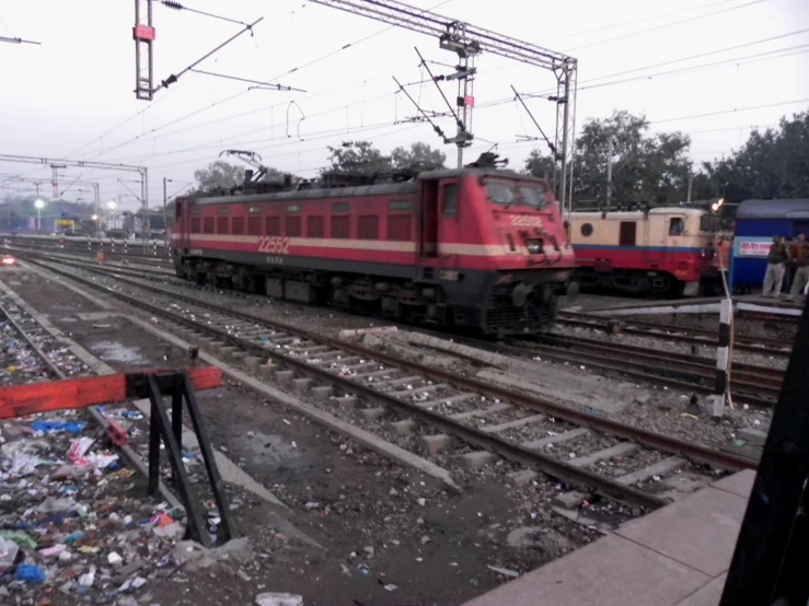 two trains parked on tracks next to a street