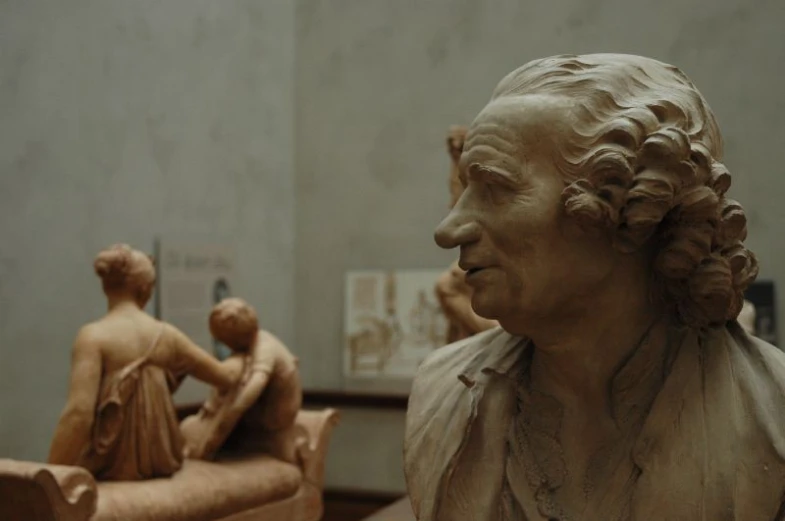 three wooden sculptures are displayed on shelves next to each other