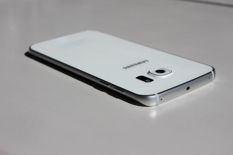close up of a white samsung smartphone on a gray table