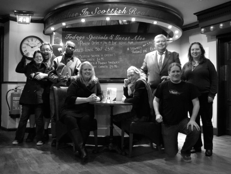 a group of people standing around a small table